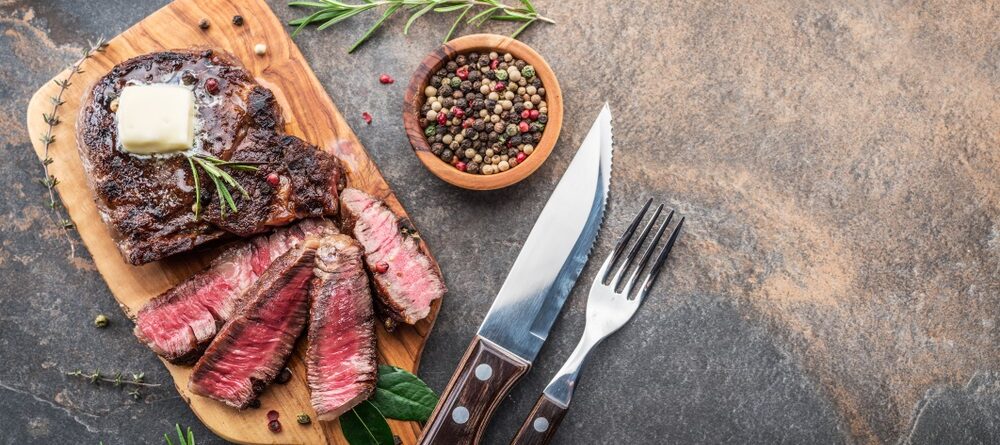 https://professionalbutcherknives.com/wp-content/uploads/2021/06/steak-knife-with-herbs-and-a-piece-of-butter-on-the-wooden-tray-view-1000x445.jpg